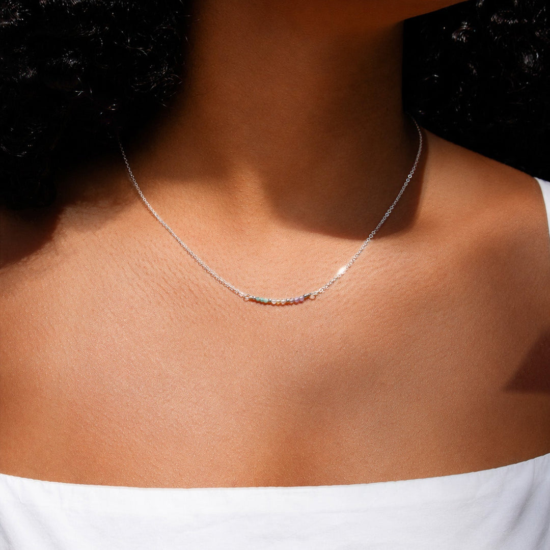 Close-up of a woman wearing a delicate necklace with a blurred background