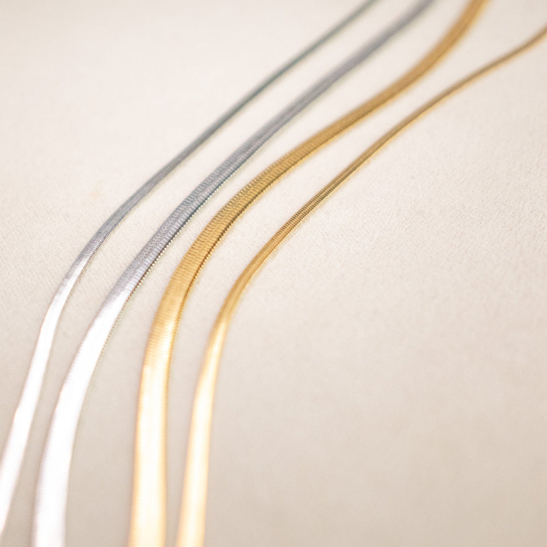 Three metallic bands in gold, silver, and bronze on a beige background