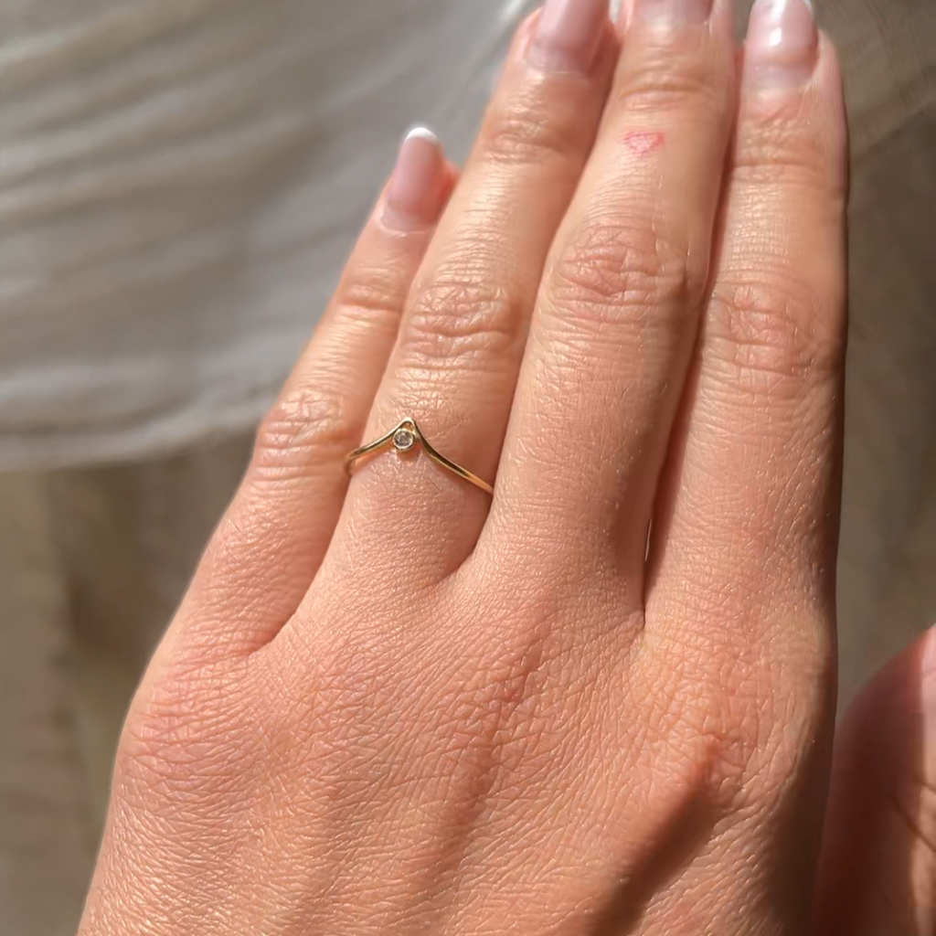 Hand with a delicate ring on a neutral background