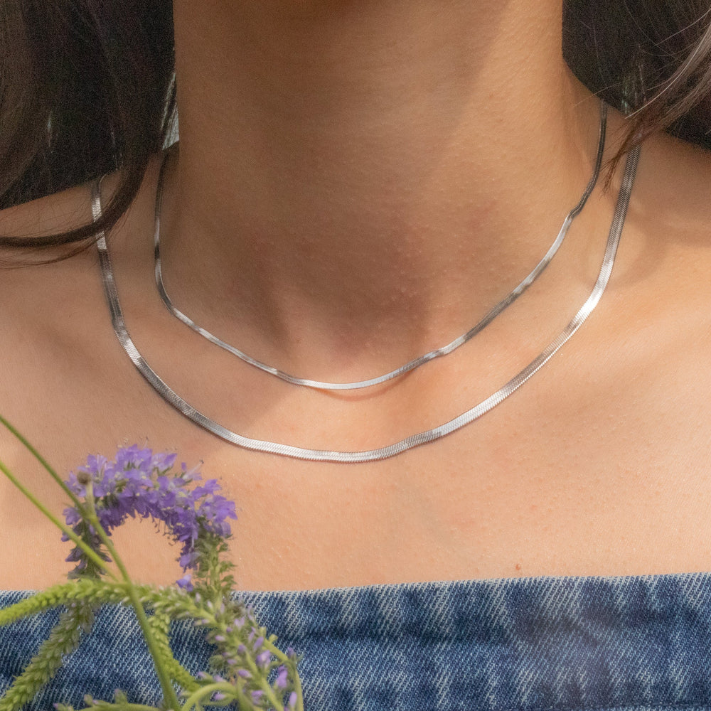 Silver necklace on a person with a blurred background