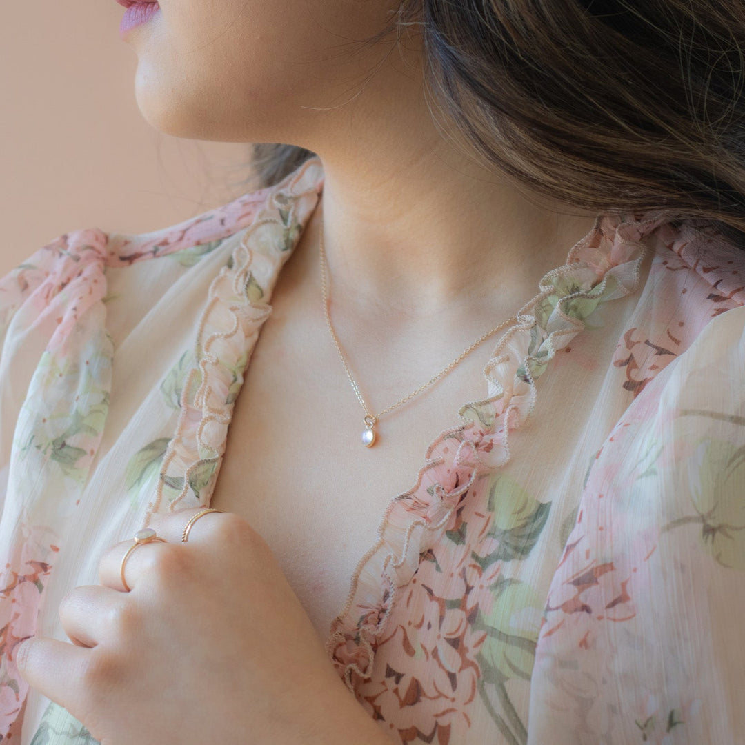 Woman wearing a floral dress with a soft pink background